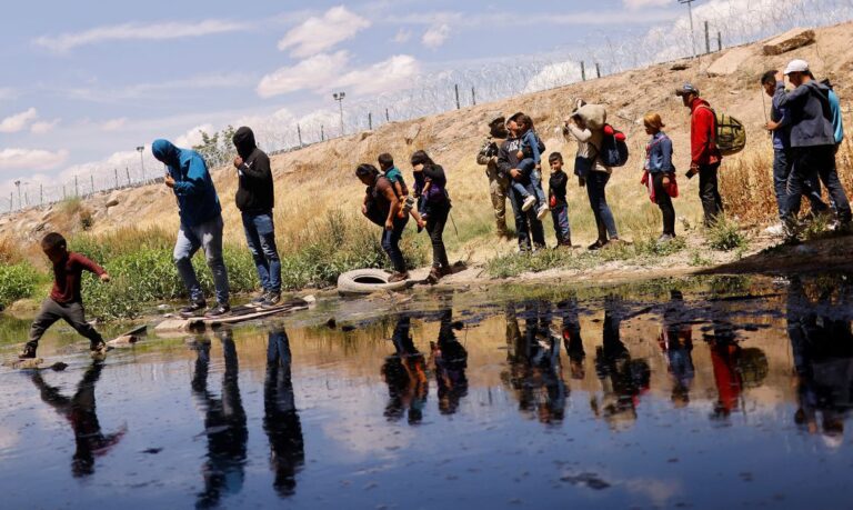 Migrantes em busca de asilo atravessam o rio Rio Bravo para retornar ao México vindos dos Estados Unidos