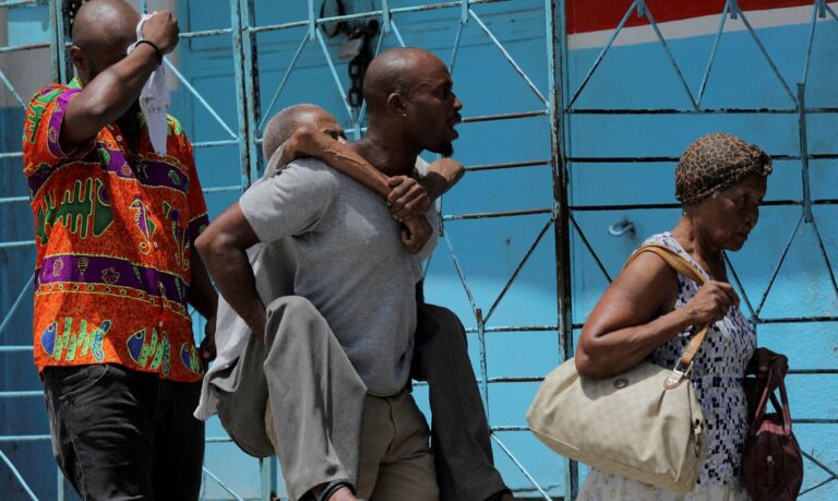 Homens carregam idosos enquanto fogem do bairro Carrefour Feullies em Porto Príncipe, no Haiti 15/08/2023 REUTERS/Ralph Tedy Erol