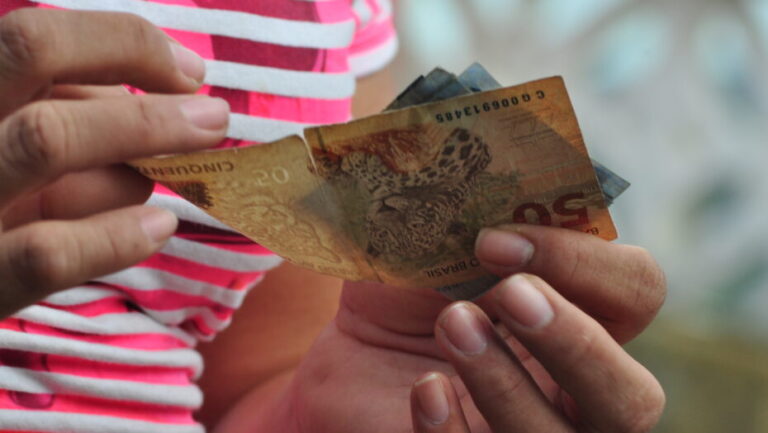 Dinheiro nas mãos de mulher. Foto: José Aldenir/Agora RN.