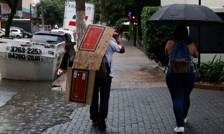 São Paulo (SP),14/03/2023 - Pessoas se protegem da chuva que deixa São Paulo em estado de atenção no final da tarde, na Rua Carlos Weber. Foto: Fernando Frazão/Agência Brasil
