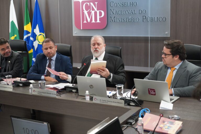 Imagem do procurador-geral da República e presidente do CNMP, Augusto Aras, e ao lado dele, outros três homens, todos sentados à mesa, em um plenário.