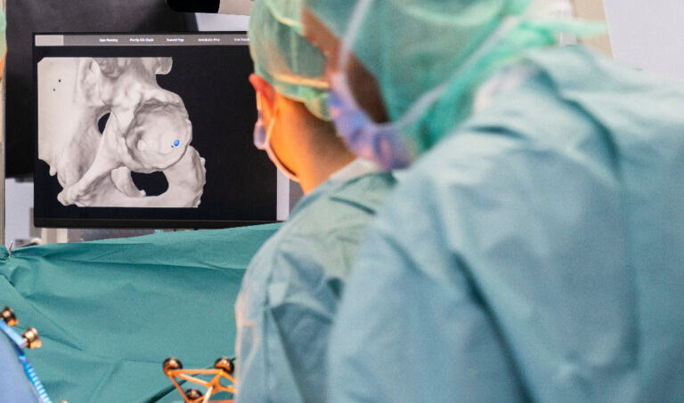 Imagem de profissionais de saúde realizando um procedimento cirúrgico de ortopedia.