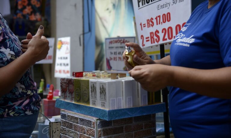 Vendedora entrega fragrâncias aos pedestres em loja na tradicional área de compras do Saara, no centro do Rio de Janeiro