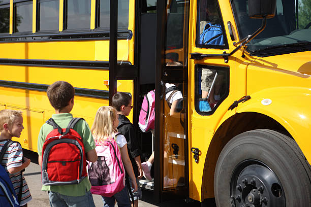 Crianças com mochilas entrando em um transporte escolar