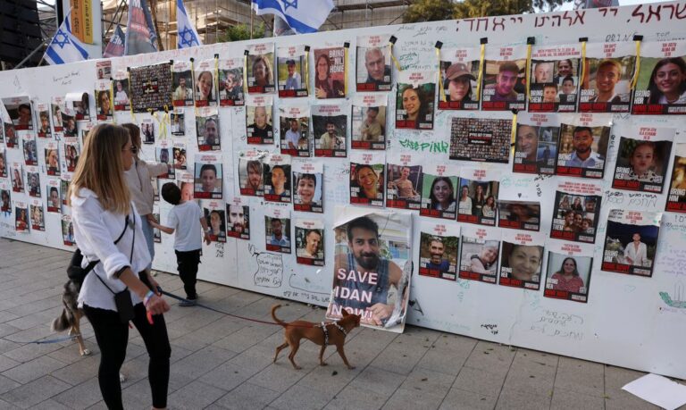 People look at an installation which shows the pictures of hostages taken by Palestinian Islamist group Hamas following a deadly infiltration of Israel by Hamas gunmen from the Gaza Strip on October 7, before some of them are due to be released as part of a deal between Israel and Hamas to free hostages held in Gaza in exchange for the release of Palestinian prisoners, in Tel Aviv, Israel, November 24, 2023. REUTERS/Ronen Zvulun