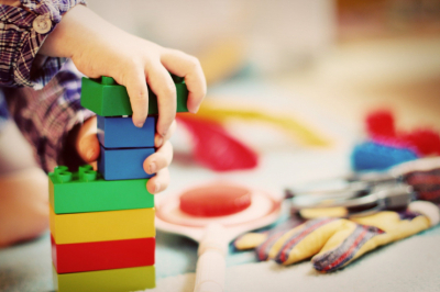 Imagem de mão de criança segurando peças de jogos educativos.