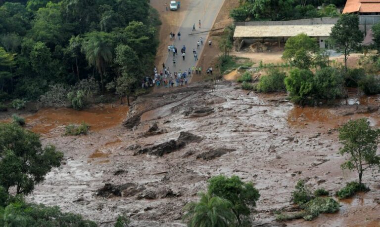 Residents are seen in an area next to a dam owned by Brazilian miner Vale SA that burst