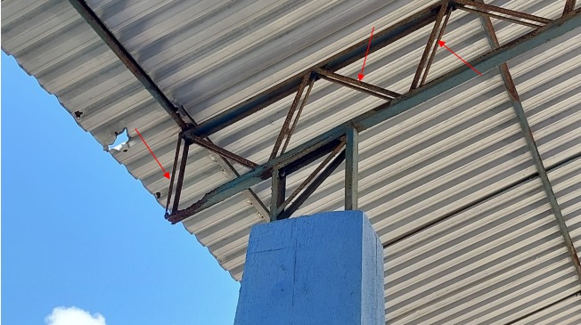 Imagem da estrutura do teto da quadra com ferrugem.