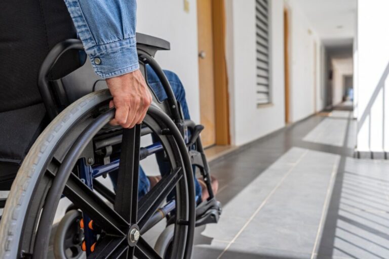Imagem de pessoa em cadeira de roda em um corredor