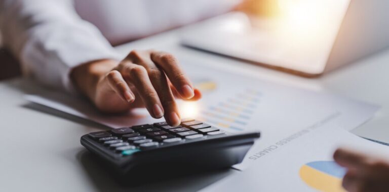 Imagem mostra mao masculina fazendo contas em calculadora