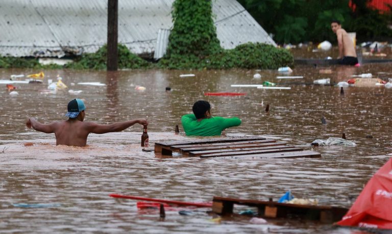 Pessoas caminham em área alagada às margens do Rio Taquari durante fortes chuvas em Encantado Rio Grande do Sul, Brasil, 2 de maio de 2024. REUTERS/Diego Vara