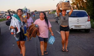 People walk carrying donated items in Eldorado do Sul, in Rio Grande do Sul, Brazil, May 6, 2024. REUTERS/Amanda Perobelli