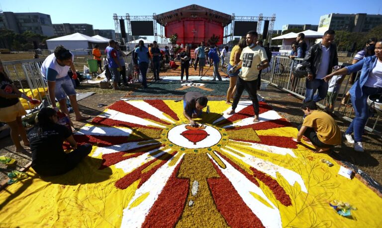 Fiéis confeccionam os tradicionais tapetes de serragem durante a Festa de Corpus Christi de Brasília, que retorna à Esplanada dos Ministérios após 2 anos de celebrações reduzidas por conta da pandemia.