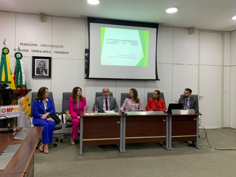 Imagem da uma mesa composta pela procuradora-geral de Justiça Elaine Cardoso, da corregedora-geral Iadya Gama Maio, dos promotores de Justiça Guglielmo Marconi, da subprocuradora-geral do MPT, Ileana Mousino, e da desembargadora do TJRN, Maria de Lourdes Medeiros.