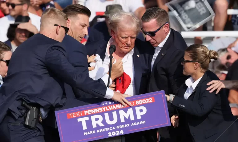 Republican presidential candidate and former U.S. President Donald Trump is assisted by security personnel after gunfire rang out during a campaign rally at the Butler Farm Show in Butler, Pennsylvania, U.S., July 13, 2024. REUTERS/Brendan McDermid     TPX IMAGES OF THE DAY