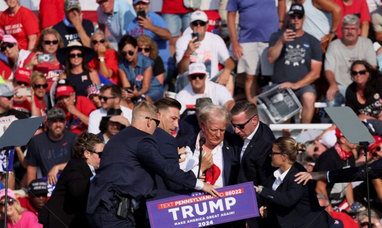 Republican presidential candidate and former U.S. President Donald Trump is assisted by U.S. Secret Service personnel after gunfire rang out during a campaign rally at the Butler Farm Show in Butler, Pennsylvania, U.S., July 13, 2024. REUTERS/Brendan McDermid     TPX IMAGES OF THE DAY