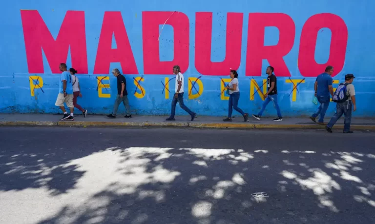 People pass by a mural saying