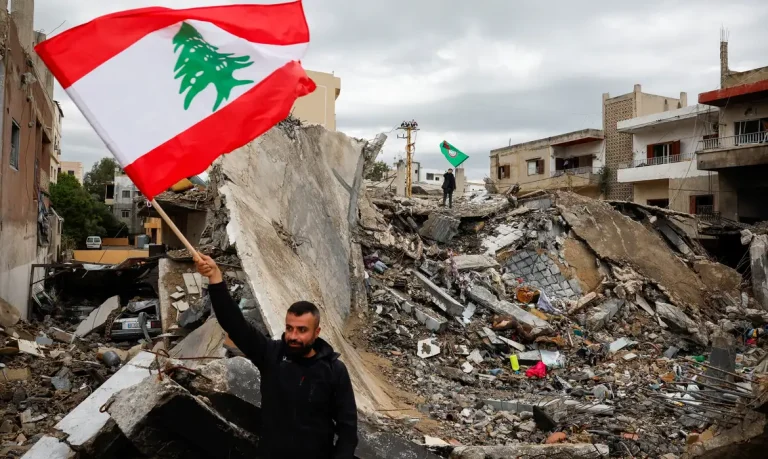 Homem com bandeira do Líbano em meio a destroços em Tiro
 27/11/2024   REUTERS/Adnan Abidi