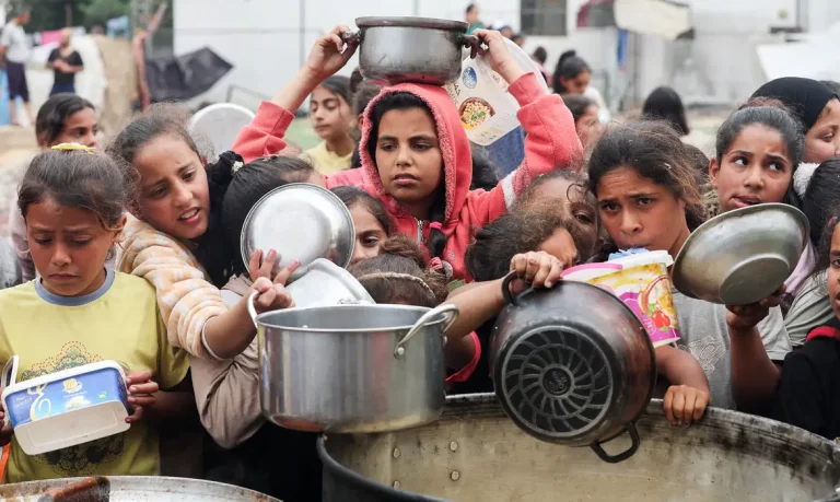Palestinos aguardam para receber comida preparada por uma cozinha comunitária, em Nuseirat, Faixa de Gaza
08/04/2025
REUTERS/Ramadan Abed