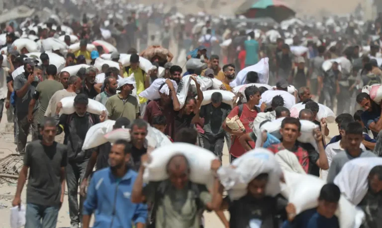 GAZA CITY, GAZA - JULY 27: Palestinians walk for kilometers after receiving flour aid distributed from trucks that entered the Zikim area, a kibbutz in southern Israel, amid ongoing Israeli attacks and severe food shortages, in Gaza City, Gaza, on July 27, 2025. Mahmoud Issa  / AnadoluNo Use USA No use UK No use Canada No use France No use Japan No use Italy No use Australia No use Spain No use Belgium No use Korea No use South Africa No use Hong Kong No use New Zealand No use Turkey