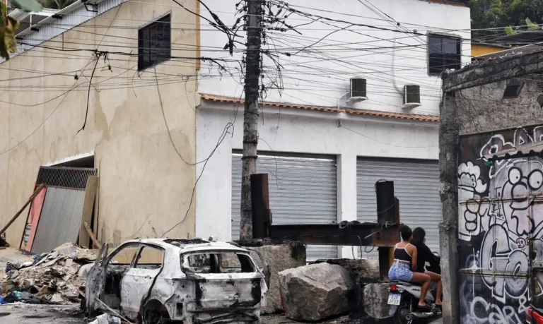 Rio de Janeiro (RJ), 30/10/2025 – Pessoas passam em moto na praça da Vila Cruzeiro ao lado de barricadas que foram colocadas para conter avanço de policiais durante a Operação Contenção. Foto: Tânia Rêgo/Agência Brasil