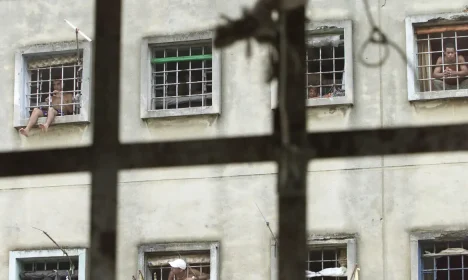 BRAZILIAN PRISONERS LOOK OUT FROM THEIR CELL AT CARANDIRU PRISON.