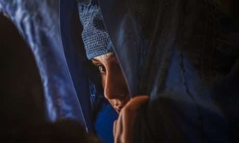 A woman speaks with an election official as she prepares to vote in the Afghan election in Mazar e Sharif in northern Afghanistan August 20, 2009.  REUTERS/Caren Firouz  (AFGHANISTAN POLITICS ELECTIONS)