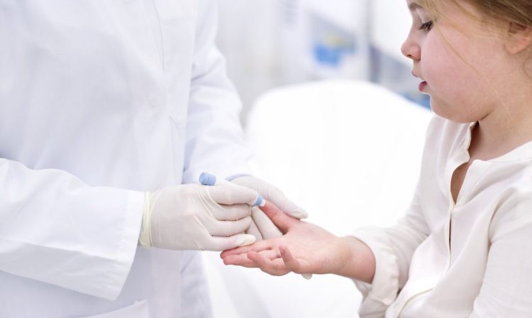 Young girl having finger prick test.No use: BBC, Pearson, Oxford University Press, Springer Nature, Dorling Kindersley, Cambridge University Press & Assessment, New Scientist, Bonnier Publications, John Wiley & Sons, The Lancet, BMJ. Criança teste de glicemia