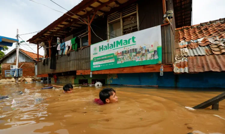 Men swim as they collect items from their houses, flooded after heavy rains in Jakarta, Indonesia, January 2, 2020. REUTERS/Willy Kurniawan