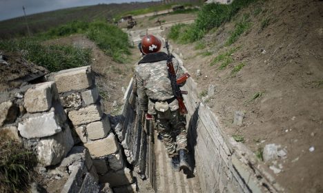 Soldados armênios étnicos caminham em uma trincheira em sua posição perto da fronteira de Nagorno-Karabakh