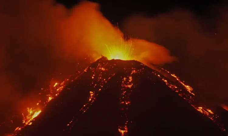 An eruption from Mount Etna lights up the sky during the night, seen from Fornazzo