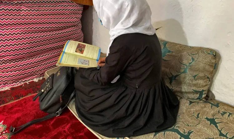 FILE PHOTO: An Afghan schoolgirl reads from her book inside a house in Kabul, Afghanistan, March 23, 2022. REUTERS/Charlotte Greenfield/File Photo