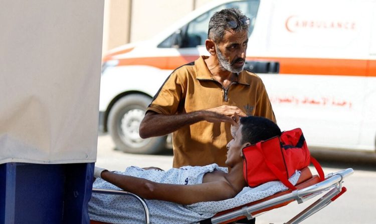 Um homem está ao lado de um palestino ferido, que receberá tratamento em um hospital egípcio, no posto fronteiriço de Rafah com o Egito, no sul da Faixa de Gaza, em 1º de novembro de 2023. REUTERS/Ibraheem Abu Mustafa TPX IMAGENS DO DIA