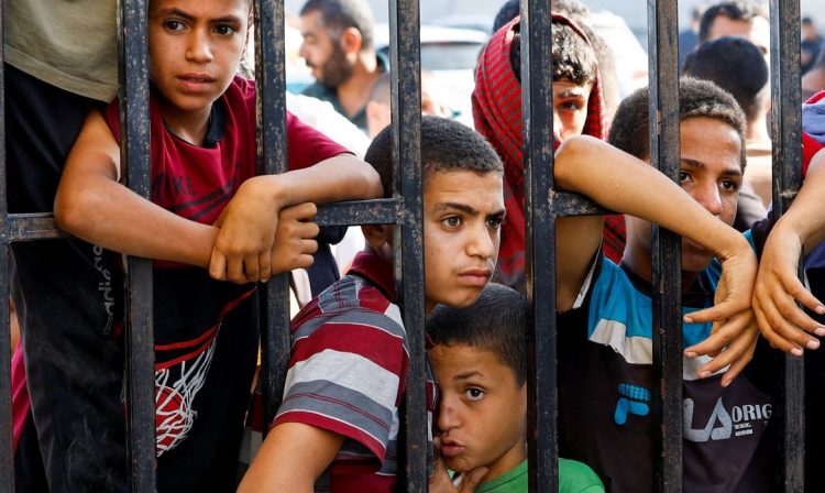 Children wait for the arrival of Palestinian workers, who were in Israel during the Hamas October 7 attack, at the Rafah border after being sent back by Israel to the strip, in the southern Gaza Strip, November 3, 2023. REUTERS/Ibraheem Abu Mustafa     TPX IMAGES OF THE DAY