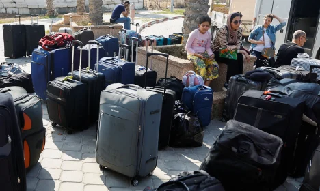 Palestinian holding a foreign passports waits for permission to leave Gaza, amid the ongoing conflict between Israel and Palestinian Islamist group Hamas, at the Rafah border crossing with Egypt, in Rafah in the southern Gaza Strip, November 3, 2023. REUTERS/Ibraheem Abu Mustafa