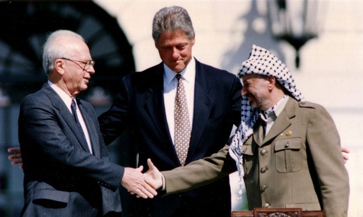 FILE PHOTO: PLO Chairman Yasser Arafat (R) shakes hands with Israeli Prime Minister Yitzhak Rabin (L), as U.S. President Bill Clinton stands between them, after the signing of the Israeli-PLO peace accord, at the White House in Washington September 13, 1993. REUTERS/Gary Hershorn/File Photo