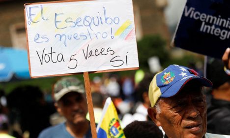 Apoiador do governo venezuelano segura cartaz durante evento em Caracas para coletar assinaturas em apoio ao referendo sobre os direitos da Venezuela sobre a região potencialmente rica em petróleo de Essequibo, na Guiana
15/11/2023 REUTERS/Leonardo Fernandez Viloria