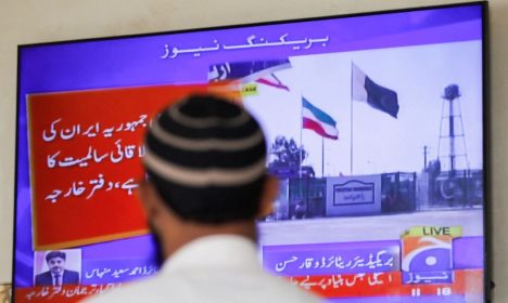 A man looks at a television screen after the Pakistani foreign ministry said the country conducted strikes inside Iran targeting separatist militants, two days after Tehran said it attacked Israel-linked militant bases inside Pakistani territory, in Karachi, Pakistan January 18, 2024. REUTERS/Akhtar Soomro