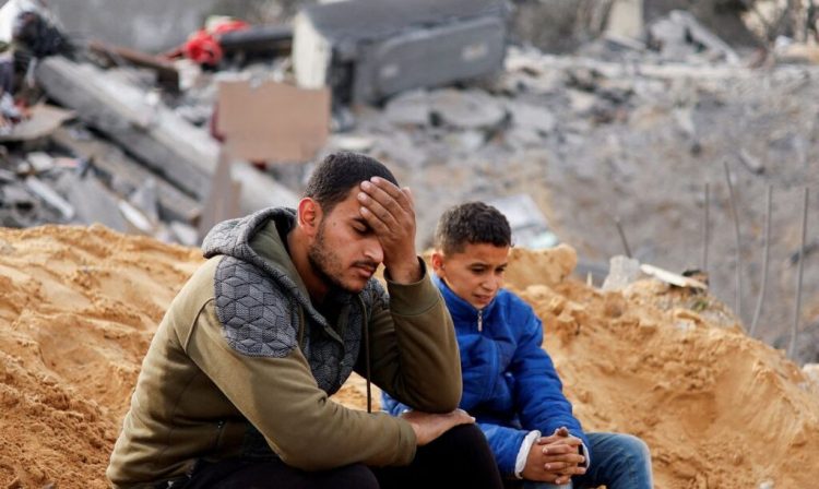 Palestinians react as they sit at the site of an Israeli strike on a house, amid the ongoing conflict between Israel and the Palestinian Islamist group Hamas, in Rafah in the southern Gaza Strip February 23, 2024. REUTERS/Ibraheem Abu Mustafa     TPX IMAGES OF THE DAY