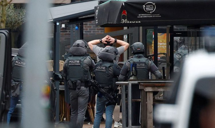 Policiais holandeses detêm uma pessoa perto do Café Petticoat, onde várias pessoas estão sendo mantidas reféns em Ede, Holanda, em 30 de março de 2024. REUTERS/Piroschka Van De Wouw TPX IMAGENS DO DIA