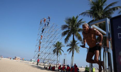 Um homem se exercita ao lado de uma estrutura para equipamentos de som para o show de Madonna na praia de Copacabana, no Rio de Janeiro, Brasil, 30 de abril de 2024. REUTERS/Pilar Olivares