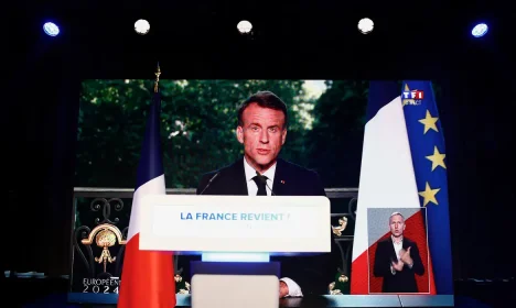 French President Emmanuel Macron speaks through a screen at the far-right National Rally (Rassemblement National - RN) party headquarters after the polls closed during the European Parliament elections, in Paris, France, June 9, 2024. REUTERS/Sarah Meyssonnier