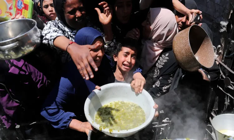 Palestinos recebem comida em Beit Lahia, norte de Gaza
 8/5/2025   REUTERS/Mahmoud Issa