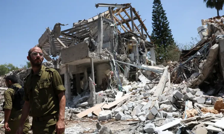 Members of Israeli forces work at an impact site following a missile attack from Iran on Israel, amid the Iran-Israel conflict, in Tel Aviv, Israel, June 22, 2025. REUTERS/Violeta Santos Moura