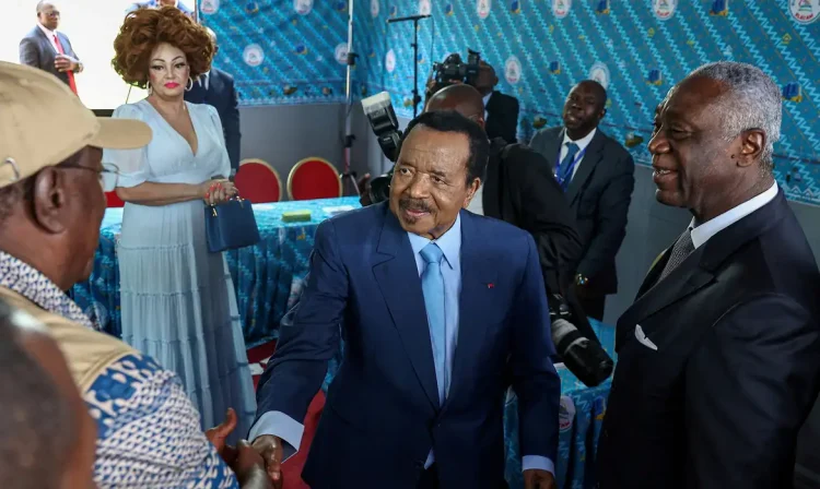 FILE PHOTO: Cameroonian President Paul Biya, 92, who is seeking an eighth term shakes hands with election observer after casting his ballot while his wife Chantal looks on, during the presidential election in Yaounde, Cameroon October 12, 2025. REUTERS/Zohra Bensemra/File Photo