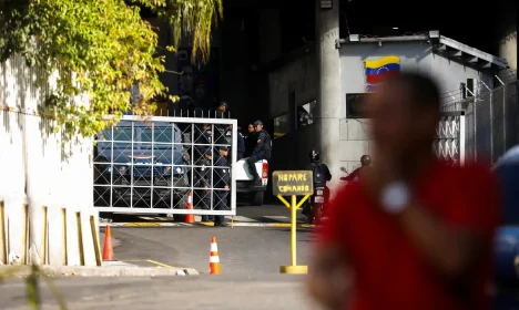 People stand next to a gate of the Bolivarian National Intelligence Service (SEBIN) headquarters, after National Assembly President Jorge Rodriguez announced that a number of foreign and Venezuelan prisoners will be released, in Caracas, Venezuela, January 9, 2026. REUTERS/Leonardo Fernandez Viloria