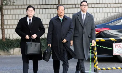 SEOUL, SOUTH KOREA - JANUARY 21: Former South Korean Prime Minister Han Duck-soo (C) arrives at the Seoul Central District Court for his first sentencing trial in the insurrection case on January 21, 2026 in Seoul, South Korea.     Chung Sung-Jun/Pool via REUTERS     TPX IMAGES OF THE DAY