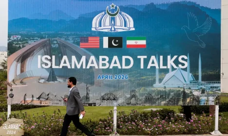 A man walks past a billboard near the media centre as delegations from the United States and Iran are expected to hold peace talks in Islamabad, Pakistan, April 11, 2026. REUTERS/Asim Hafeez     TPX IMAGES OF THE DAY        REFILE - CHANGING FROM