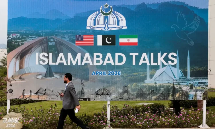 A man walks past a billboard near the media centre as delegations from the United States and Iran are expected to hold peace talks in Islamabad, Pakistan, April 11, 2026. REUTERS/Asim Hafeez     TPX IMAGES OF THE DAY        REFILE - CHANGING FROM