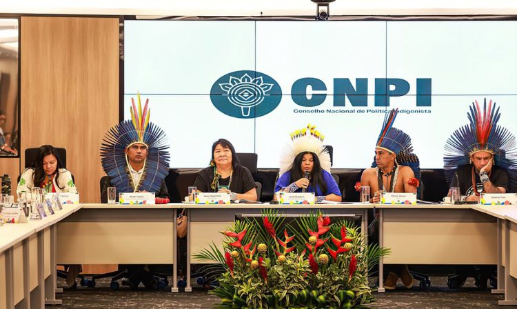 Brasília, 17/04/2024 - Em cerimônia histórica, o Ministério dos Povos Indígenas (MPI) reinstalou e empossou os membros do Conselho Nacional de Política Indigenista (CNPI). No evento, a presidenta da Fundação Nacional dos Povos Indígenas (Funai), Joenia Wapichana, destacou a importância da reconstrução da política indigenista de forma compartilhada com os demais órgãos do Governo Federal, a partir das propostas deliberadas no CNPI. A presidenta Joenia tomou posse como membro titular representando a Funai; Lucia Alberta, como 1ª suplente; e Mislene Metchacuna, na 2ª suplência. Ambas são diretoras de Promoção ao Desenvolvimento Sustentável e de Administração e Gestão da Funai, respectivamente. A cerimônia ocorreu nesta quarta-feira (17) na sede do Ministério da Justiça e Segurança Pública (MJSP), em Brasília.   Foto: Lohana Chaves/Funai